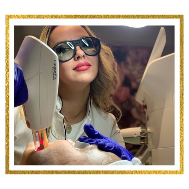 Doctor using the laser on patient face